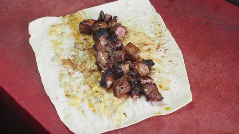 preparing a shawarma with grilled liver