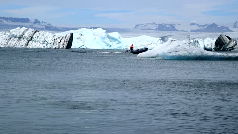 A-man-is-on-a-small-boat-near-huge-Icebergs