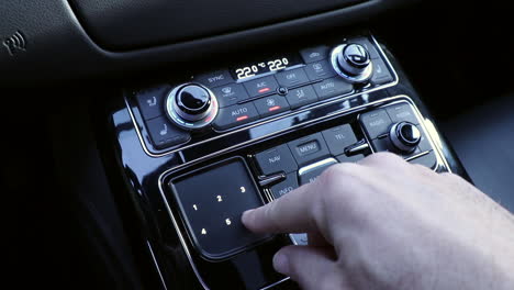 Hand-operating-luxury-car-console-close-up