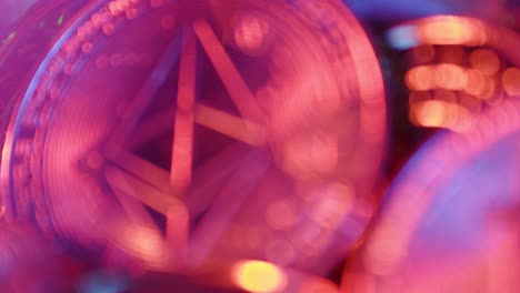zooming out to a bitcoin with colorful coins reflecting red light, symbolizing the dynamic nature of cryptocurrency and the evolving digital economy.