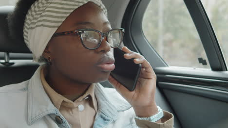 young african american woman talking on phone during car ride