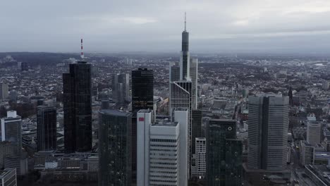 fly above large city on cloudy day. aerial panoramic footage of office towers in business borough. frankfurt am main, germany