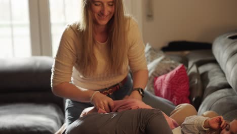 woman playing with child on couch at home