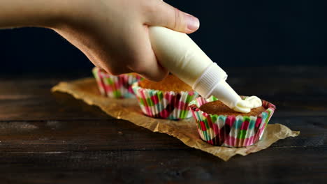 chef vertiendo crema para pasteles decorando. horneando muffins. muffins decoración