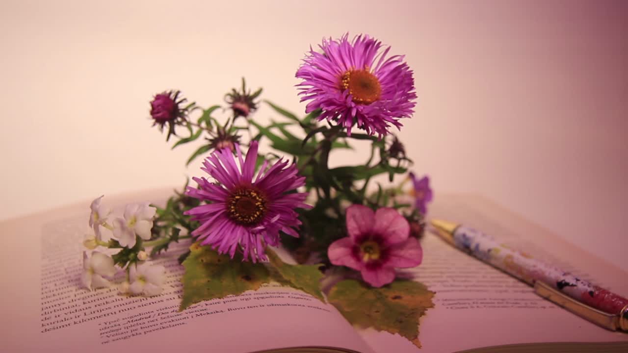 Close-up Bunga dan Pena di atas Buku