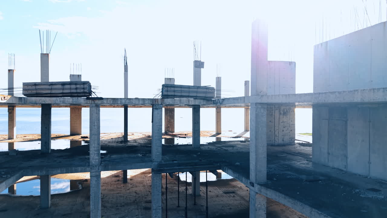 Construction of a new high-rise building at the sea shore. Sun dazzles the vast seascape at backdrop