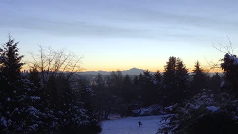 Unrecognizable-person-running-happily-on-winter-day,-Mount-Baker-in-background