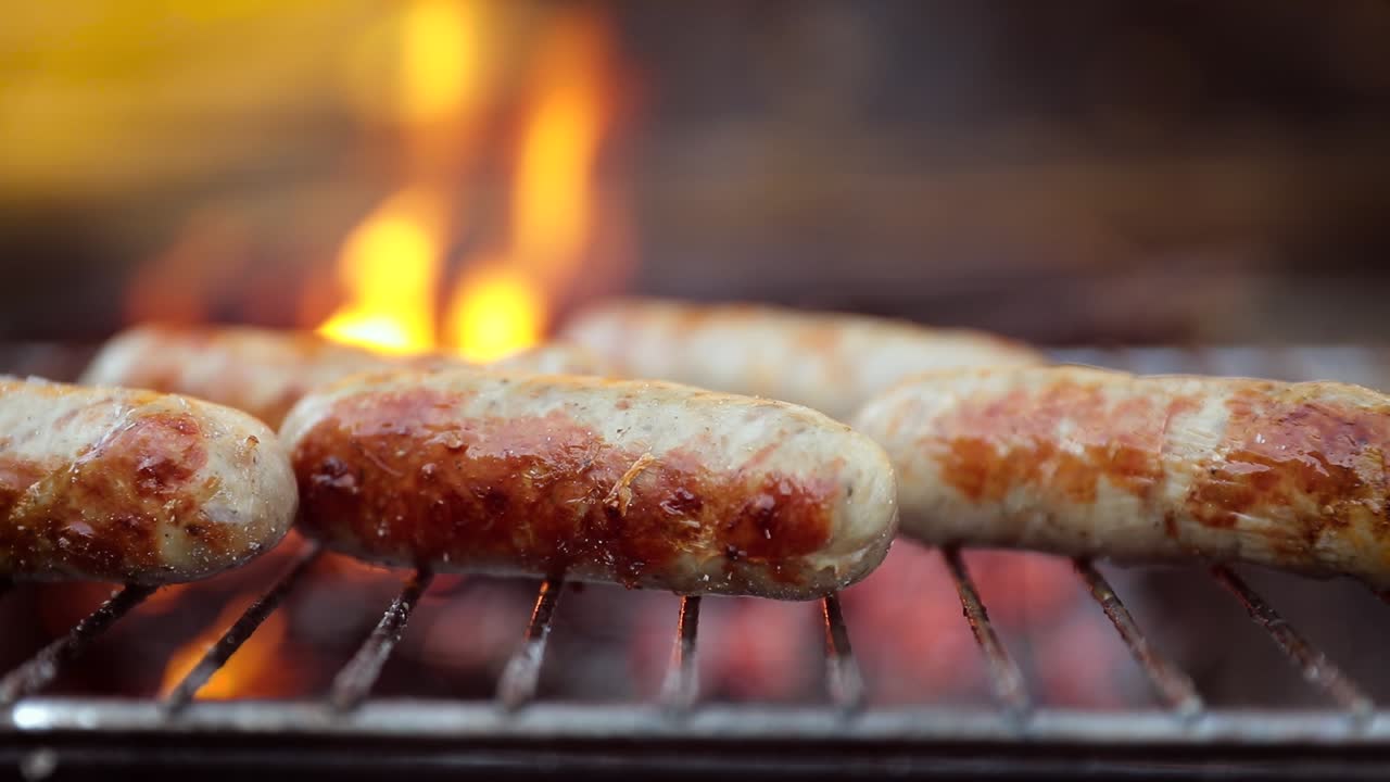 deliciosas salchichas jugosas, cocinadas en la parrilla con un fuego