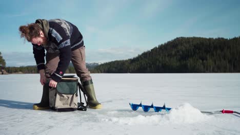 a man is getting ready for ice fishing over frozen lake