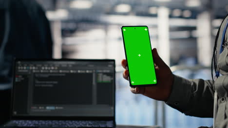 engineer using isolated screen smartphone in server room while optimizing ai