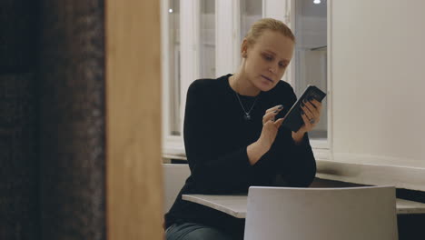 Woman-in-cafe-texting-on-mobile