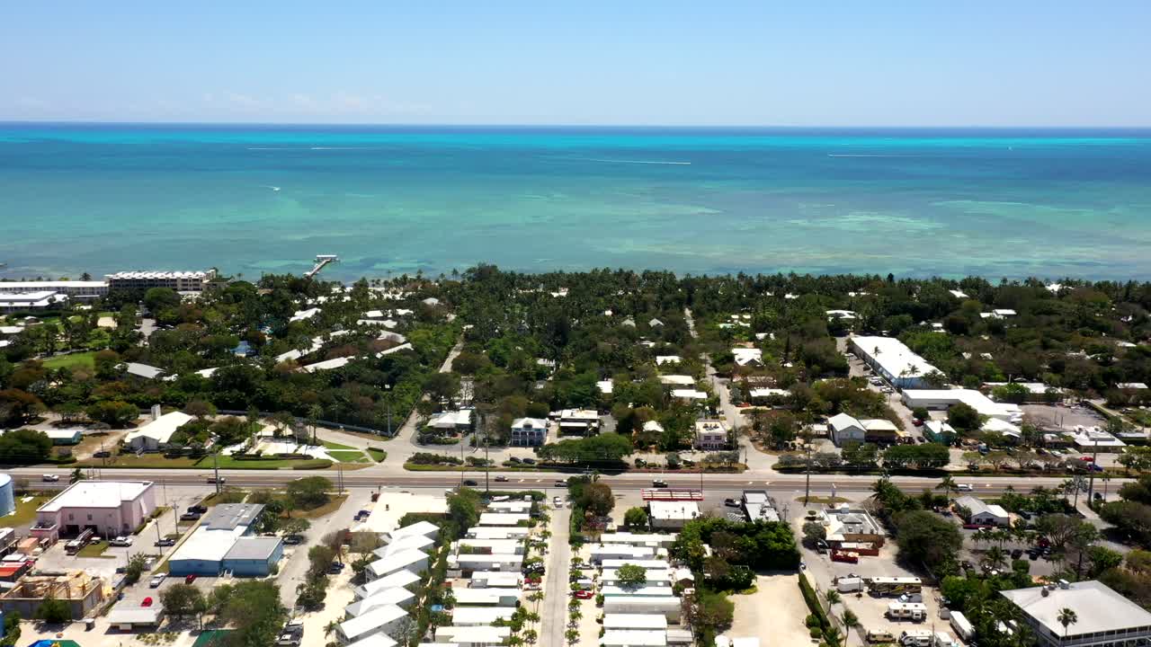 Drone approach above suburban area near coast with turquoise sea in Islamorada