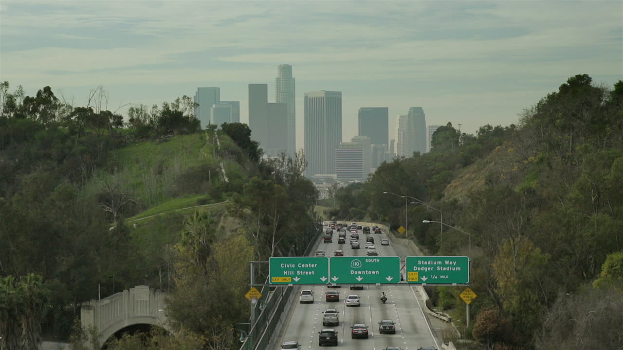 Heavy traffic flows into downtown Los Angeles, California on a cloudy day.