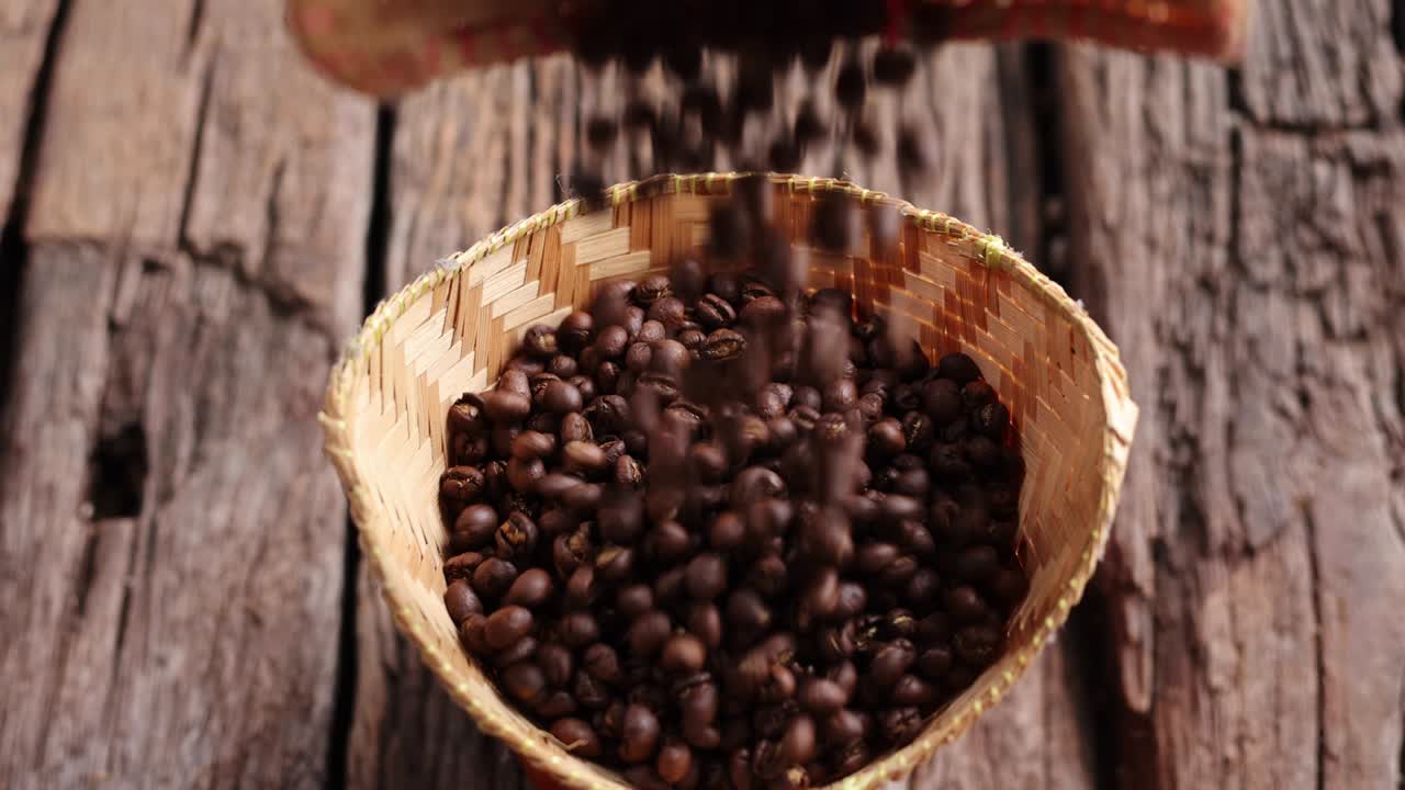 frijoles de café peaberry de pequeño tamaño recogiendo la caída de la canasta de bambú tronco de madera de fondo. enfoque selectivo en primer plano con espacio de copia.