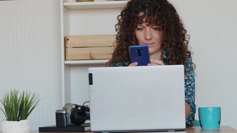 Mujer-Usando-Un-Teléfono-Inteligente-Y-Trabajando-Desde-Casa