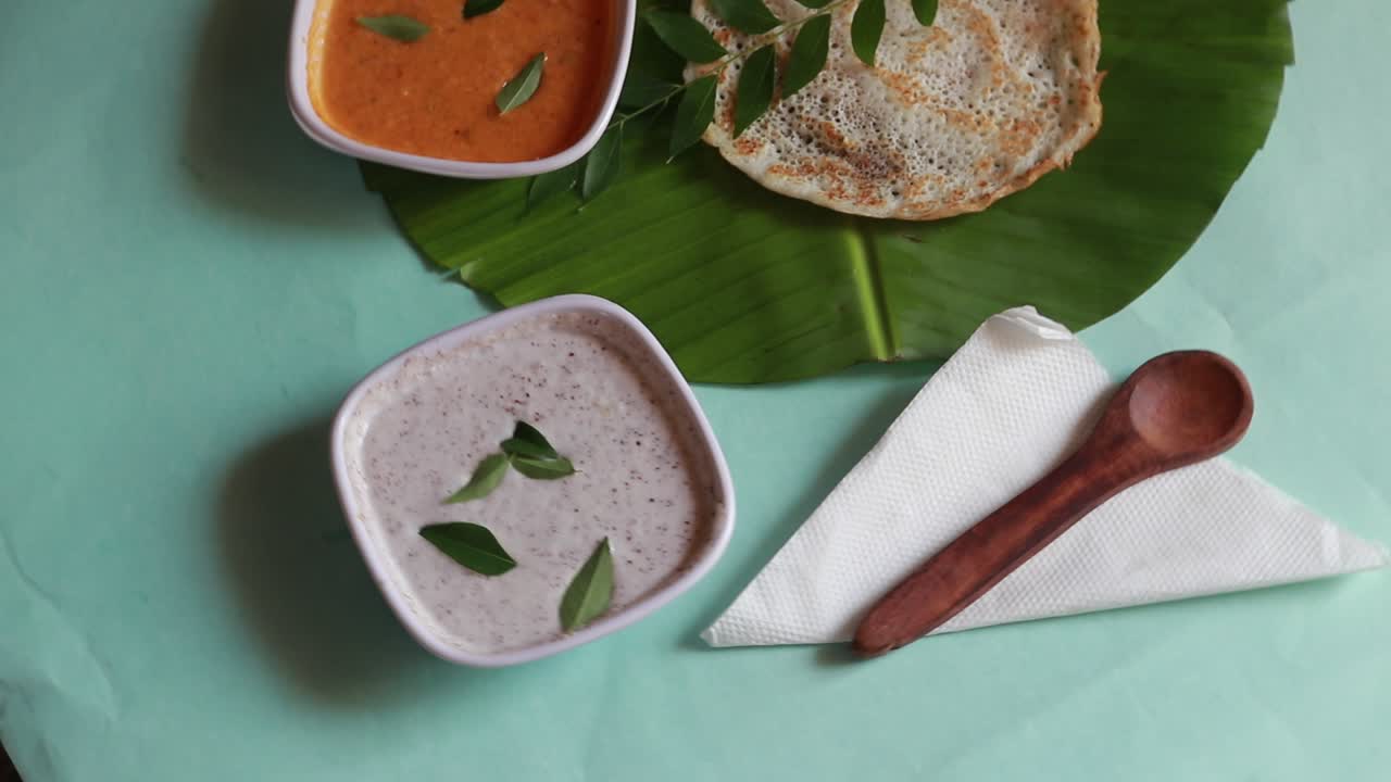 set dosa es un 'conjunto' de 2 dosas cubiertas con mantequilla o ghee y chutney sobre fondo verde