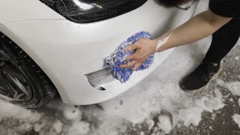 tesla model 3 getting carwash with tech wiping the front bumper