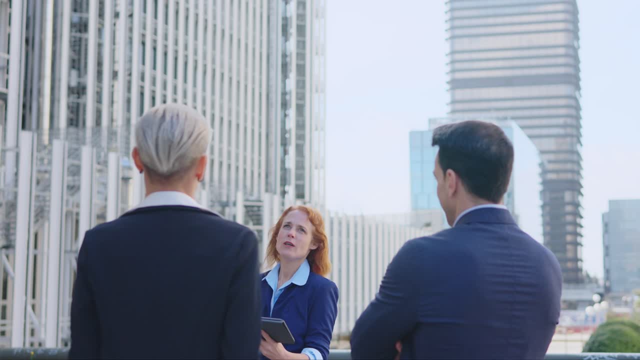 Business professionals having a discussion outdoors in a modern city setting