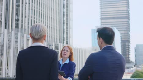 business professionals having a discussion outdoors in a modern city setting