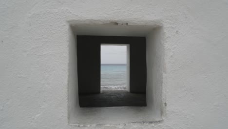 Beautiful-view-of-the-sea-through-a-white-Slave-hut's-window-on-Bonaire,-Dutch-Caribbean,-South-America