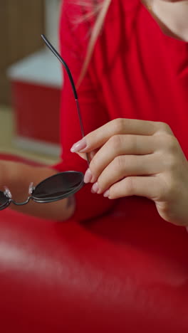woman buying sunglasses in shop. close up of woman in optician store holding stylish sunglasses
