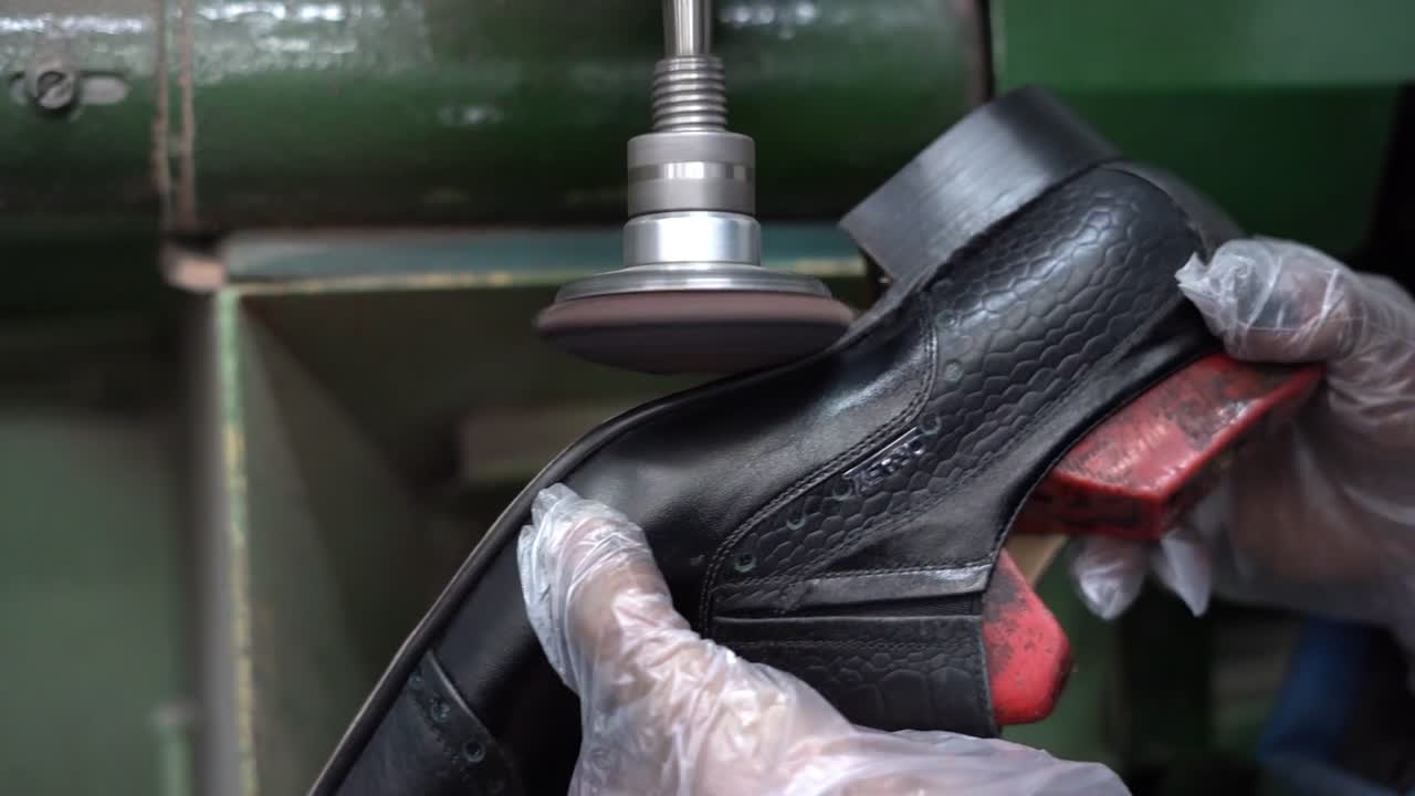 a craftsman handmade a shoe by a machine, close up shot, insert shot