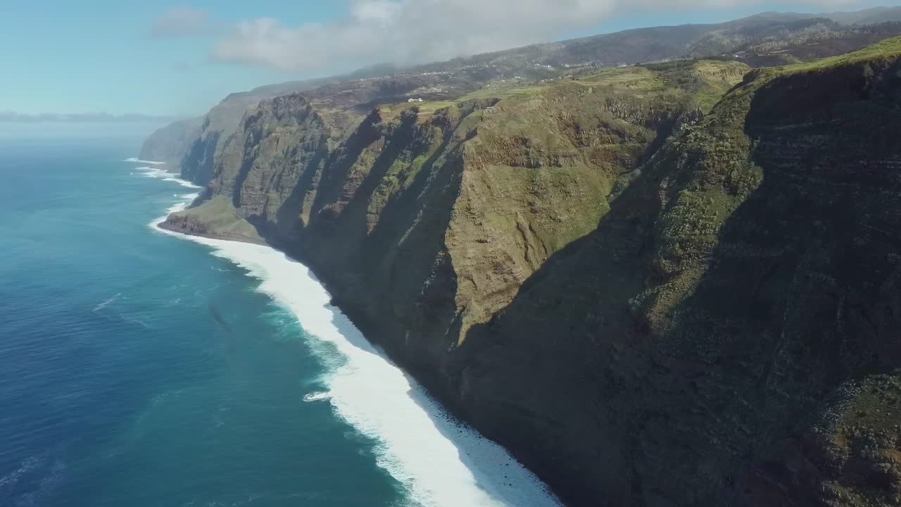포르투갈 마데이라 섬의 거대한 절벽에 위치한 폰타 두 파르고 등대 주변을 비행합니다.