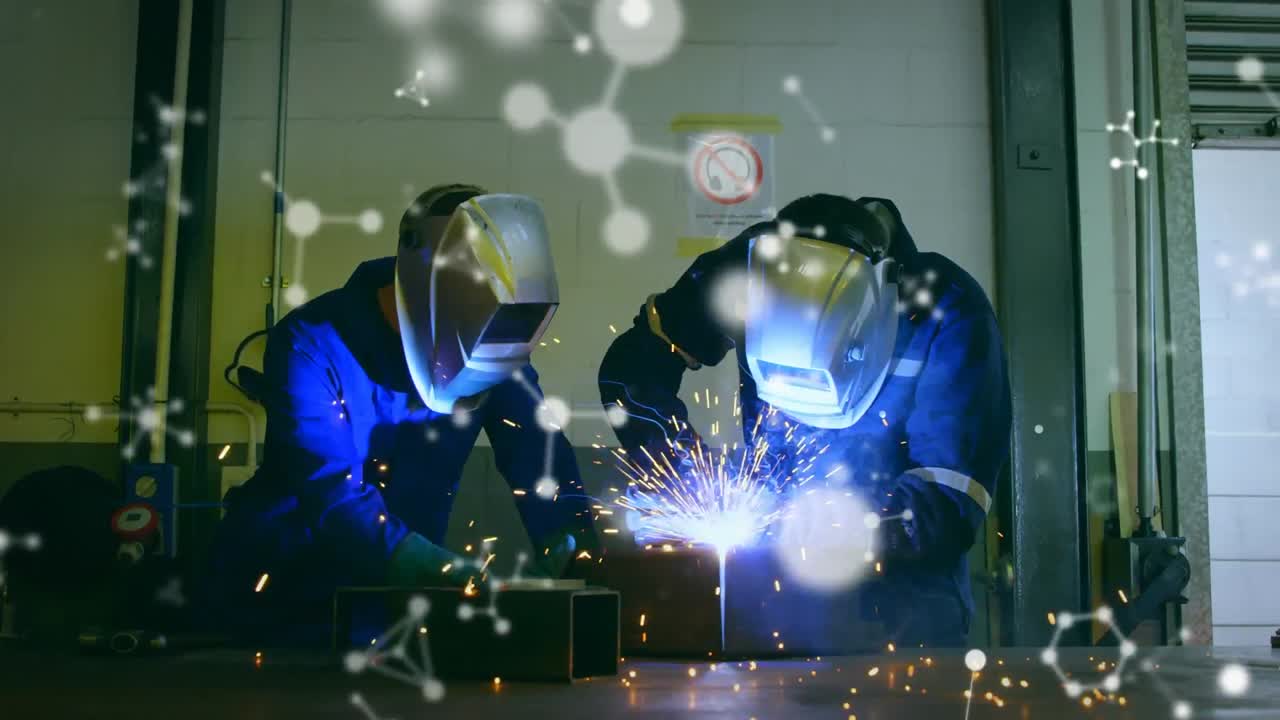 Animation of white molecules over male engineers welding