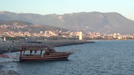 a ship is anchored in the harbor with a lighthouse visible in the distance
