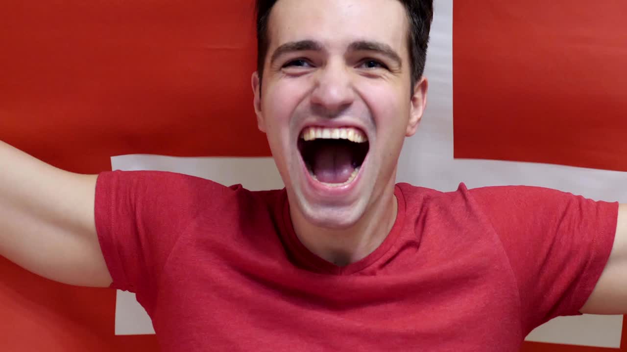 스위스 젊은이가 느린 동작으로 스위스 발을 들고 축하합니다.