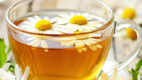 steaming chamomile herbal tea brewing in transparent glass cup, presenting delicate white and yellow flowers on rustic wooden surface, embodying wellness and relaxation