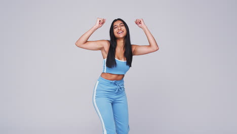 wide angle studio shot of young woman against white background dancing in slow motion