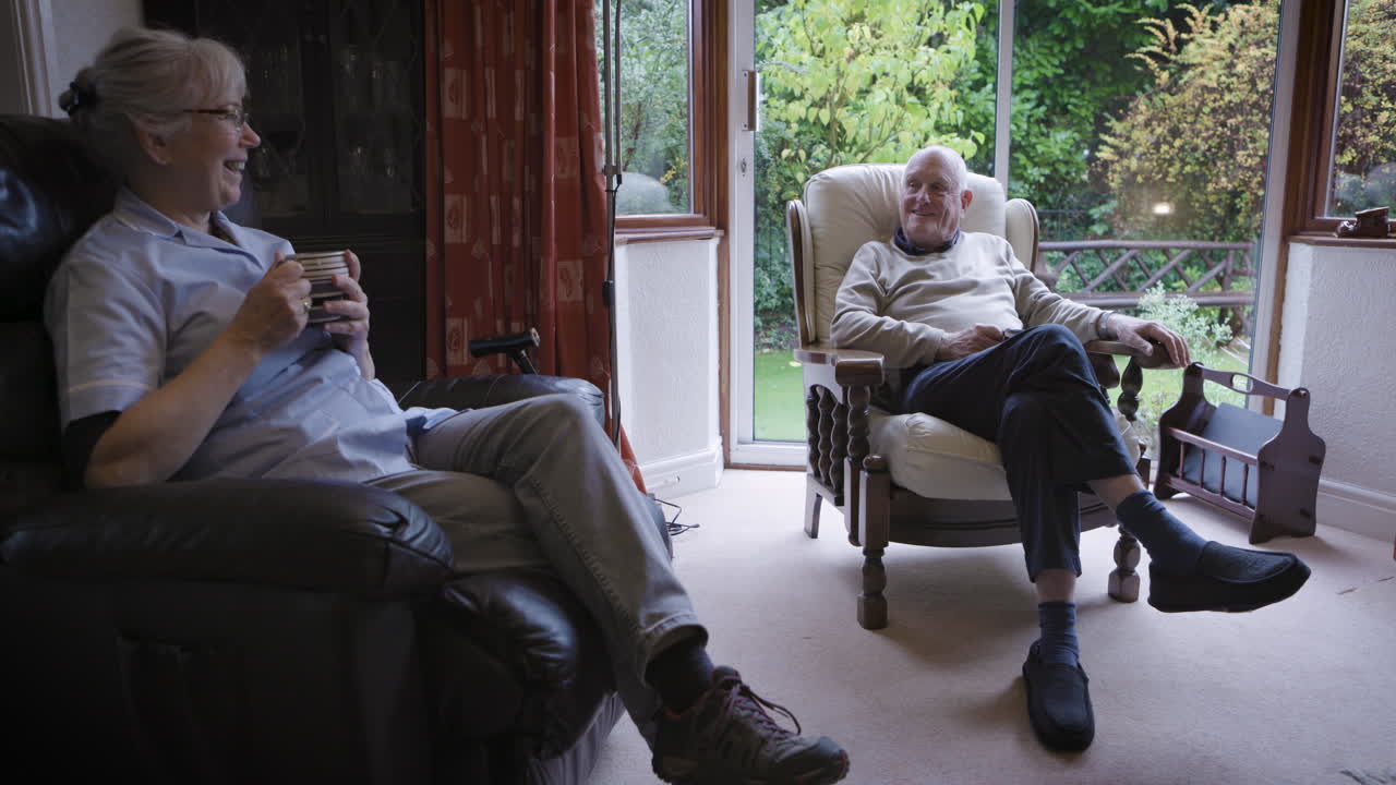 Elderly man and nurse relaxing indoors