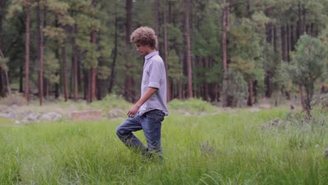 Un-Joven-Salta-De-Una-Roca-En-El-Campo-Y-Cruza-Un-Arroyo,-Gira-A-La-Izquierda