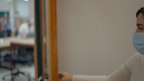 woman wearing a mask using a fingerprint scanner