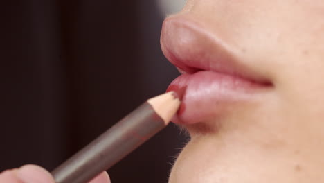 applying red lipstick on beautiful lips