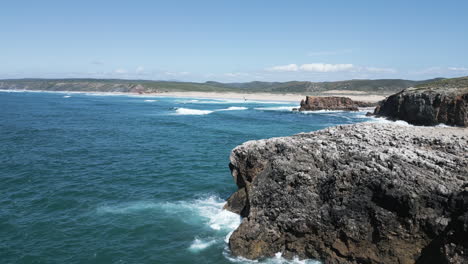 Aerial-view-of-a-powerful-collision-of-ocean-waves-against-the-majestic-cliffs-and-rocks-along-the-shoreline