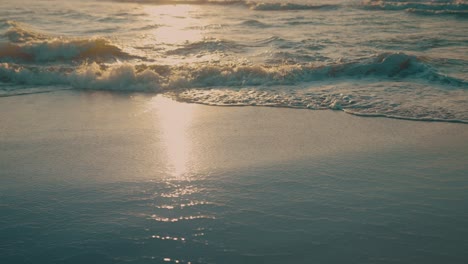 Waves-on-beach-during-sunset,-slow-motion