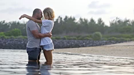 una pareja enamorada abrazándose en el agua.