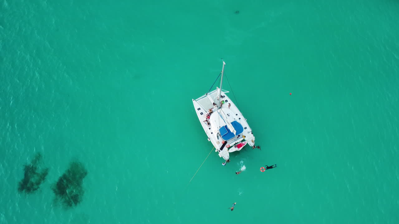 buceadores en catamarán en aguas turquesas cerca de la isla de mujeres, méxico