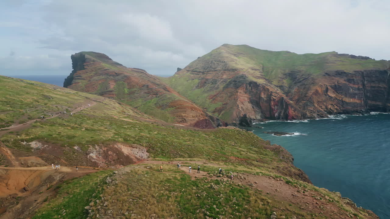 Aerial wild green coast on sunny day. Tranquil blue ocean water washing cliffs