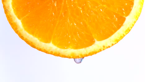 water or oils dropping on an orange slice , fruit for diet and healthy food