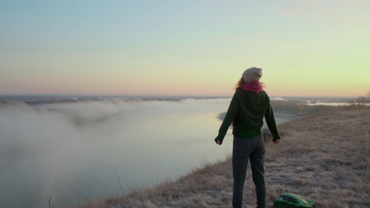 Woman Hiking at Sunrise with Foggy River View