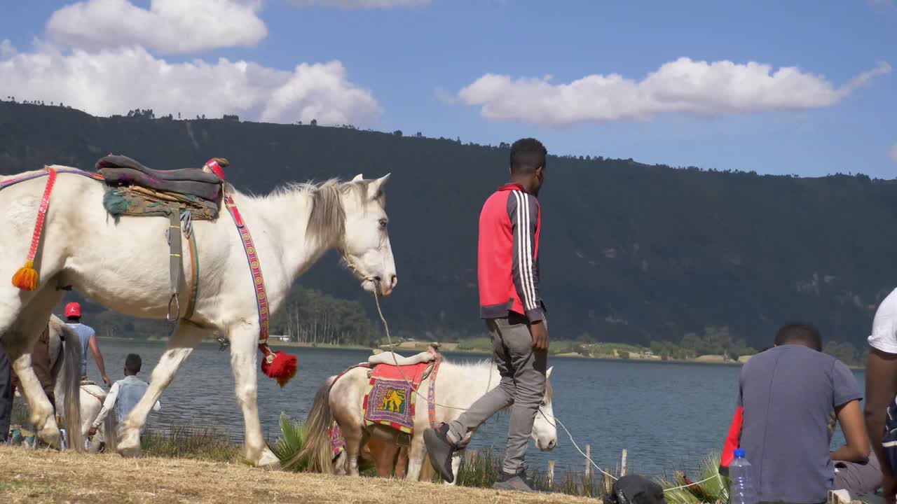 horse riders are renting the horses for money to the visitor of the lake, and enjoying the lake view.