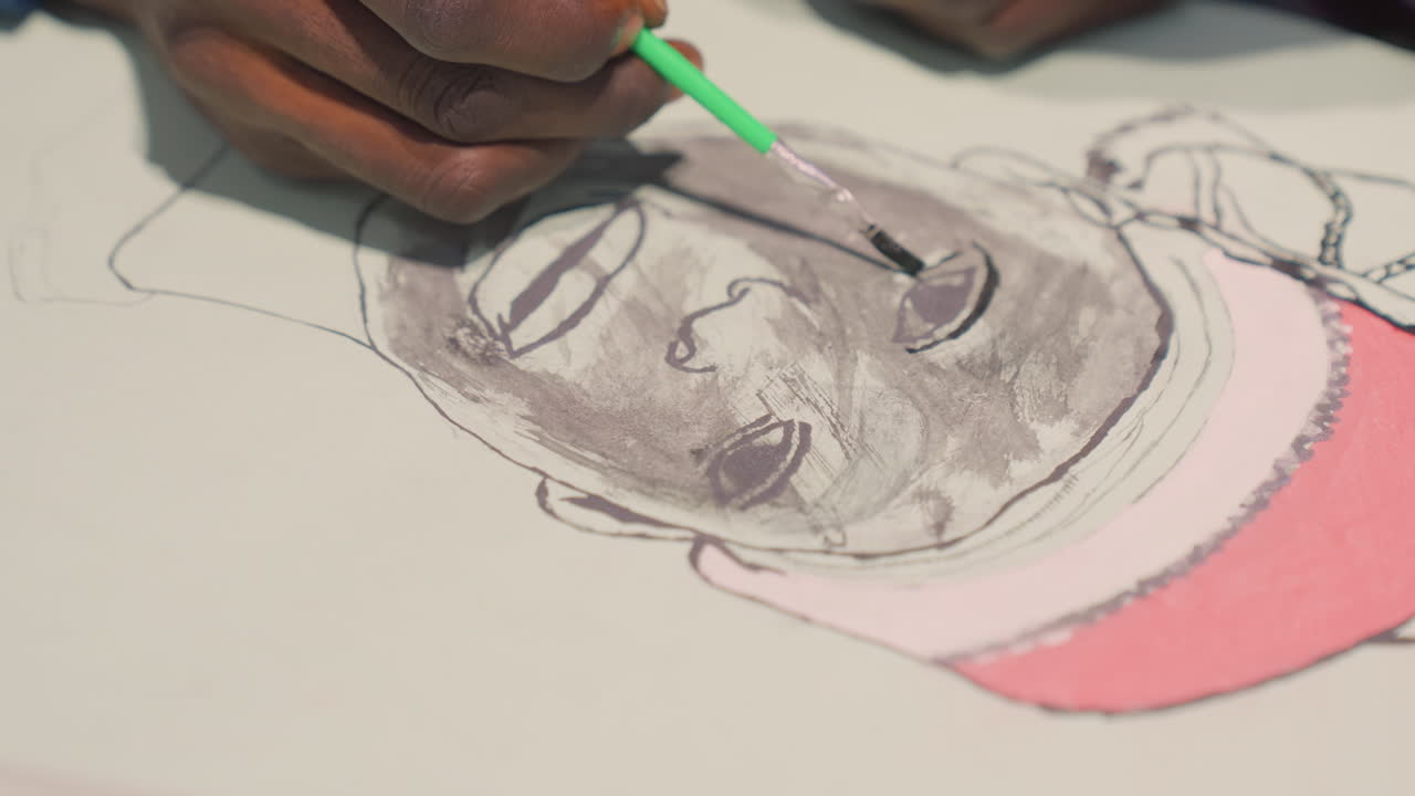 Artista adiciona os toques finais. Close-up de artista aplicando tinta. Momento de calma enquanto o artista finaliza o trabalho de retrato. O artista sombreia cuidadosamente os olhos e o boné com tinta escura e um pincel verde