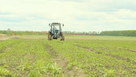 el tractor agrícola está fertilizando el campo de cultivo con nutrientes fertilizantes