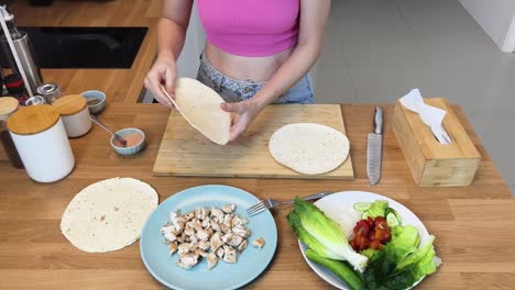 woman making chicken wraps