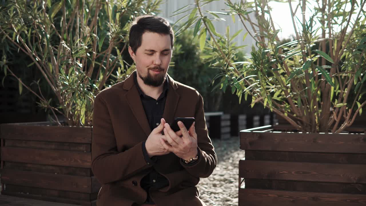 밖에서 스마트폰을 사용하는 남자