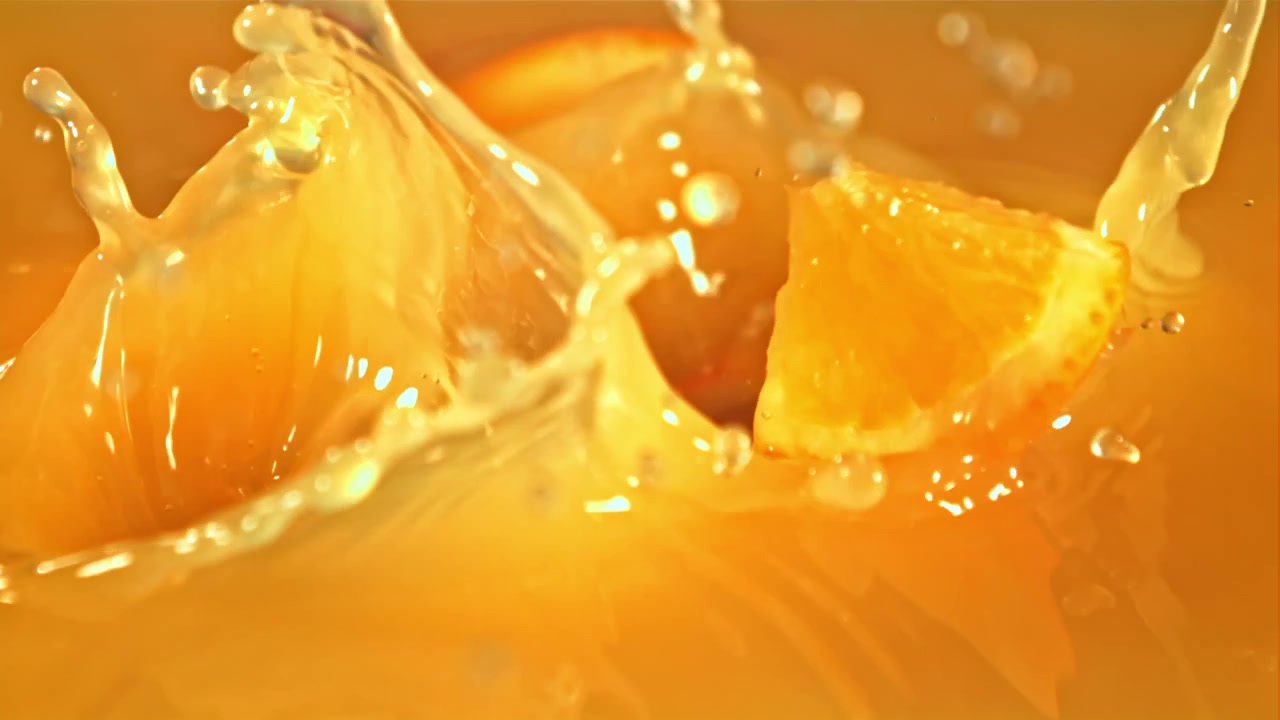 Fette d'arancia che schizzano in succo fresco al rallentatore.