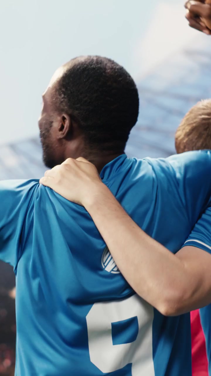 Vertical Video Soccer teammates celebrating winning goal with raised arms